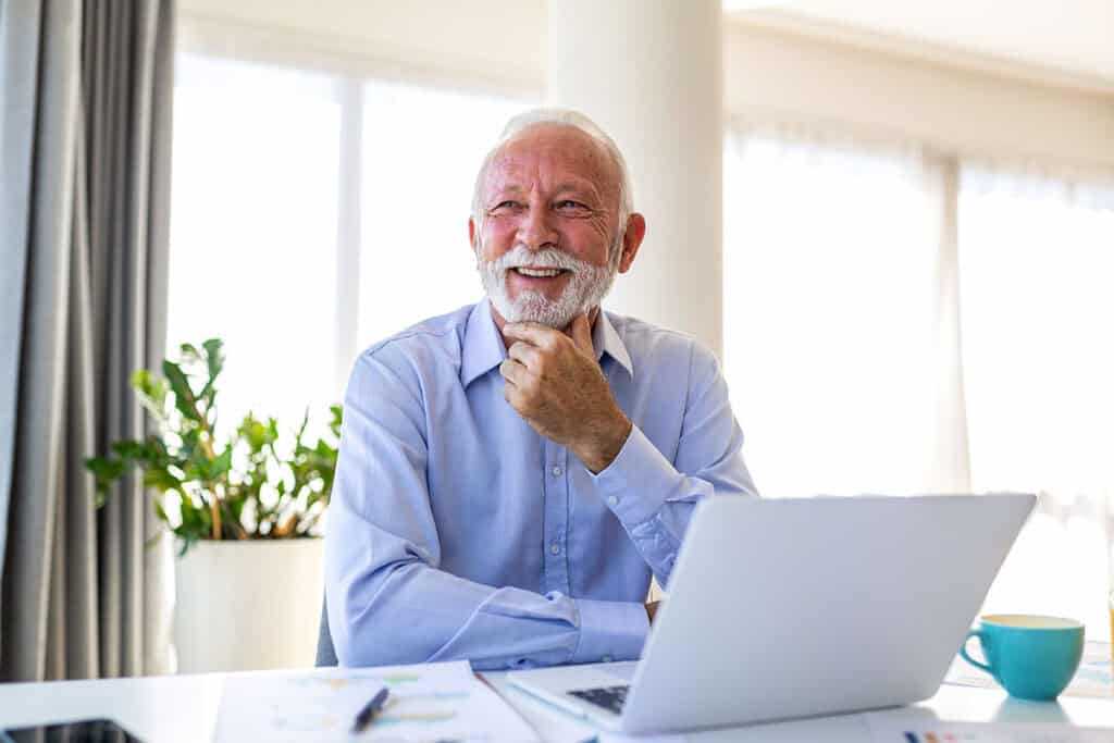 Mature businessman smiling with good posture at his desk